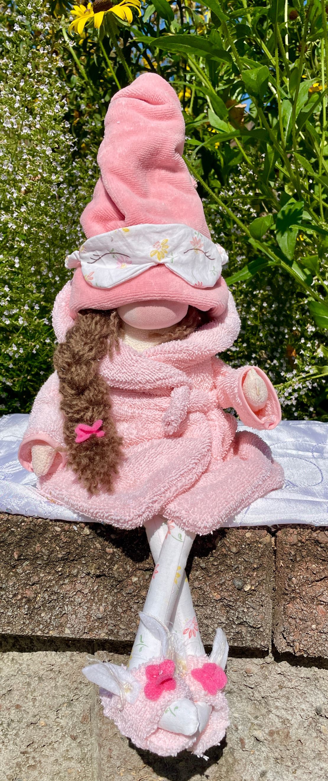 Self-care gnome in peach bathrobe and slippers with a sleep mask at PCM Linden Hills Minneapolis